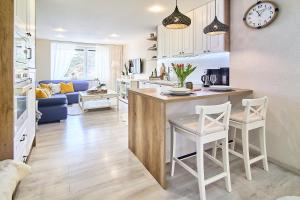 a kitchen and living room with a table and chairs at Smart apartmány Prešov in Prešov