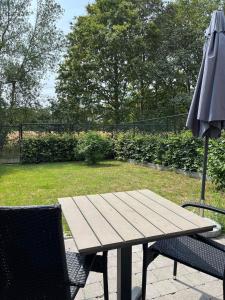 ein Picknicktisch und ein Sonnenschirm auf einer Terrasse in der Unterkunft Bleekhoeve in Olen + 1 Foto