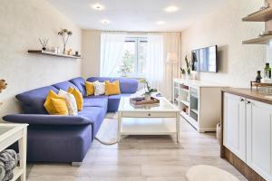 a living room with a blue couch and yellow pillows at Smart apartmány Prešov in Prešov