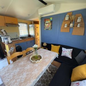 a living room with a table and a couch at Chez Elvis et Agnès, logement climatisé in Saint-Loup