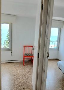 a room with a red chair and a window at Frontal con vistas in Benicàssim +14 photos