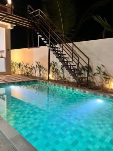 a large swimming pool with blue tiles in a building at Nilah Private Pool Villa in Kappil