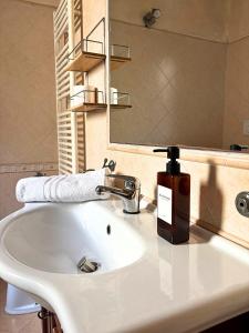a bathroom sink with a soap dispenser and a mirror at Aura LT - Vicinissima all'aeroporto in Fiumicino +27 photos