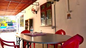 a dining room table with red chairs around it at A K Homestay in Sungai Petani