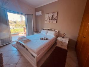 a bedroom with a bed and a large window at Bruskos Holiday Deluxe in Kynopiástai
