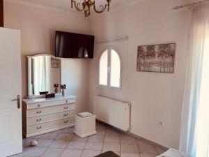 a bathroom with a dresser and a window and a dresser at Bruskos Holiday Deluxe in Kynopiástai