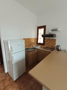 a kitchen with a white refrigerator and a sink at Kalama Apartments in Kalamos