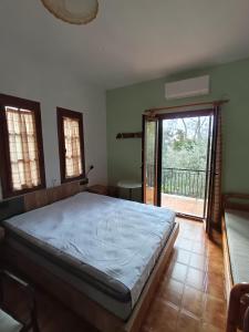 a bedroom with a bed and a door to a balcony at Kalama Apartments in Kalamos