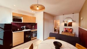 a kitchen with a black refrigerator and a table at Le Modern Silhouette - Home Homy in Montluçon