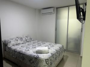a bedroom with a bed with a towel on it at San Luis Apartamento 102 Cúcuta in Cúcuta