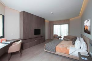 una camera d'albergo con letto, scrivania e TV di Promenade Hotel a Beirut