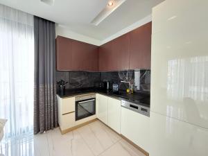 a kitchen with brown cabinets and a counter top at SA Apartments! Luxury 2BR with Private Beach Access in Alanya +118 photos