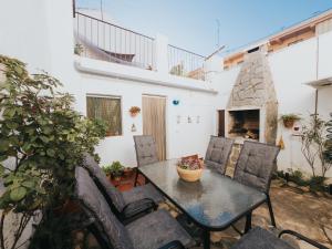 a patio with a table and chairs and a fireplace at Casa de la Cueva in Figueroles