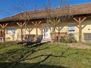 two chairs sitting in front of a house at Enikő Vendégház in Vajdácska