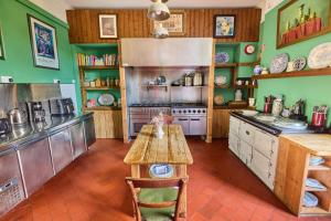 a kitchen with green walls and a table and a refrigerator at Preston House in Abbeyleix +70 photos