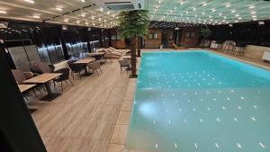 a swimming pool with tables and chairs in a building at Relax Apartment in Vrnjačka Banja