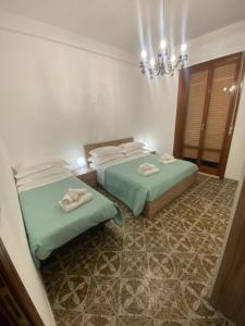 a bedroom with two beds and a chandelier at The Shamrock House in Palazzolo Acreide +58 photos