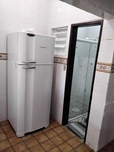 a white refrigerator in a kitchen with a mirror at Doce lar do Ipase in São Luís