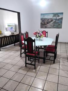 a dining room with a table and chairs with flowers on it at Doce lar do Ipase in São Luís