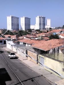 a white car parked on a street with buildings at Doce lar do Ipase in São Luís