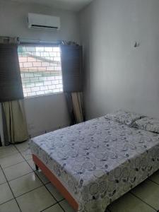 a bedroom with a bed in a room with a window at Doce lar do Ipase in São Luís