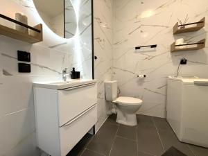 a white bathroom with a toilet and a sink at w Centrum in Inowrocław +6 photos