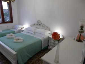 a bedroom with a bed and a vase with a rose at The Shamrock House in Palazzolo Acreide
