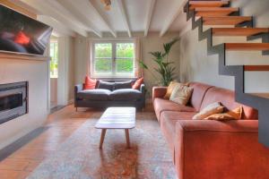 a living room with a couch and a staircase at The River Cottage in Middelkerke