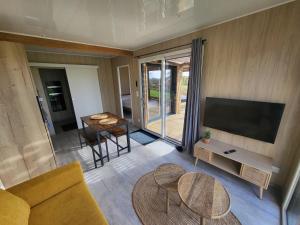 a living room with a couch and a flat screen tv at La cabane des folies in Montmédy