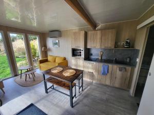 a living room with a table and a kitchen at La cabane des folies in Montmédy
