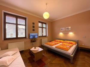 a bedroom with two beds and a flat screen tv at Penzion Andrej in Ružomberok