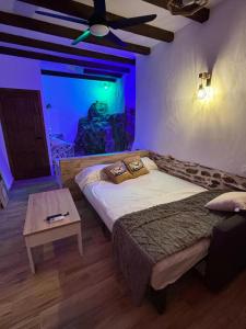 a bedroom with a large bed and a table at Los Tumbaos - El Tumbao Hidromasaje entre roca natural in Laroya