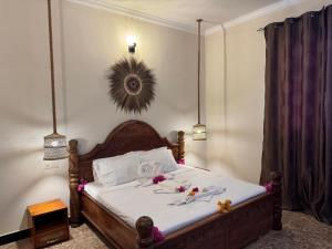 a bedroom with a bed with white sheets and flowers on it at Kendwa Sky Hotel in Kendwa +80 photos
