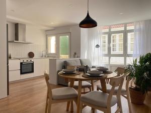 a kitchen and living room with a table and chairs at A Ribeira - BoaOnda in Cee
