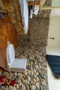 a bathroom with a stone floor and a toilet at Kivu Paradis Resort in Nyamyumba