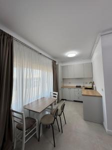 a kitchen and a table and chairs in a room at DE Apartment in Rădăuţi