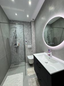 a bathroom with a toilet and a sink and a mirror at DE Apartment in Rădăuţi