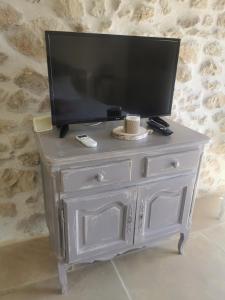 a white dresser with a tv on top of it at La petite plaine in Clansayes