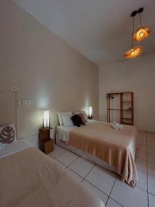 a bedroom with two beds and two lights on the wall at Pousada Porto Búzios in Búzios