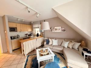 a living room with a couch and a kitchen at Strandbrise App 17 in Neuhaus
