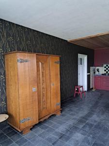 ein Zimmer mit Holzschränken und einem roten Stuhl in der Unterkunft Dereshoeve in Bunschoten