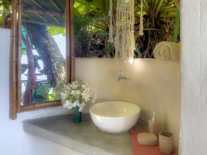 a bathroom with a bowl sink and flowers on a counter at Finca Exótica in Carate