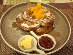 a plate of breakfast food with french toast and butter at Wanderlust Bed and Breakfast Puerto Princesa in Puerto Princesa City +23 photos