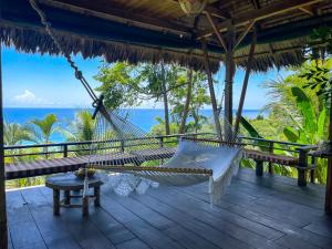 a hammock on a deck with a view of the ocean at Finca Exótica in Carate
