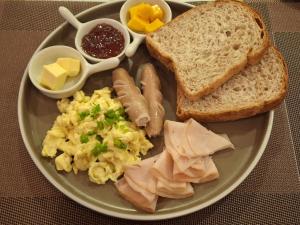 a plate of breakfast food with eggs sausage and bread at Wanderlust Bed and Breakfast Puerto Princesa in Puerto Princesa City