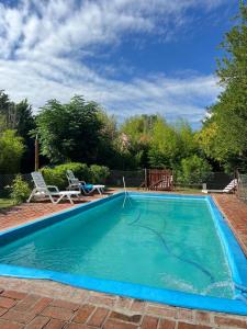 a swimming pool with a hose in the water at Cabañas Rio de Oro in Mina Clavero