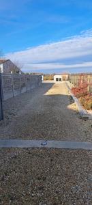 an empty road with a fence on the side at Gîte du Chemin vert in Taugon