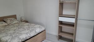 a small bedroom with a bed and a refrigerator at Gîte du Chemin vert in Taugon