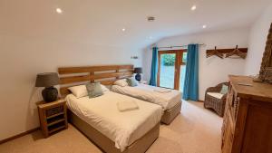 a bedroom with two beds and a window at The Vineyard in Fowey