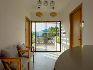 a living room with a table and chairs and an open door at Silver Bay Kamadhoo in Kamadhoo